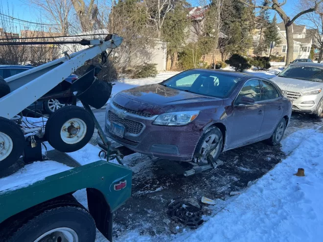 Towing service rescuing a car from a frozen puddle of water in Chicago, where the car was unable to free itself, demonstrating our efficient winter roadside assistance.