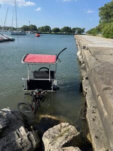 Pedicab partially submerged in Diversey Harbor before recovery in Chicago