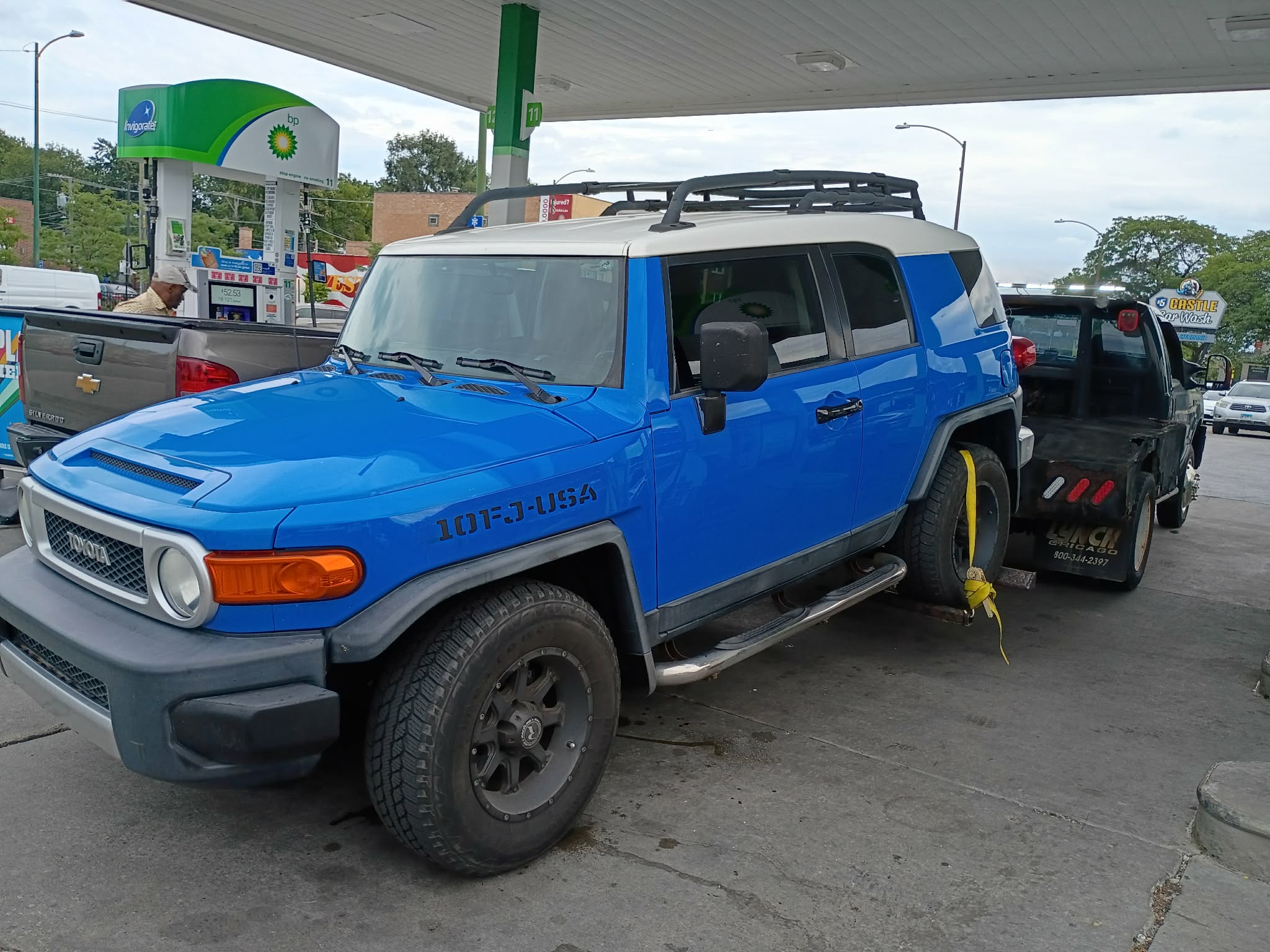 Toyota FJ Cruiser being dropped off by wheel-lift tow truck at 7130 N Western Ave in Chicago