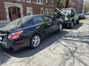 Black sedan wheel lift on residential street.