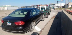 Black volkswagen sedan wheel lift pickup.