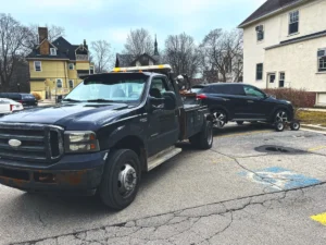 Black wheel lift truck with dark crossover.