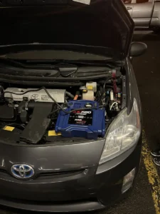 Blue jump starter in toyota engine bay.