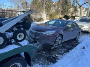 Purple sedan wheel lift in snow.
