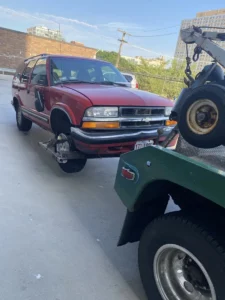 Red suv wheel lift pickup.
