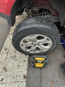 Removed wheel and portable tire inflator.