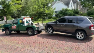 Silver suv wheel lift on brick street.