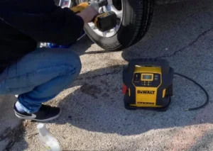 Technician using impact wrench on wheel.