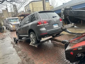 Volkswagen touareg wheel lift and dollies in alley.