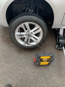 White vehicle wheel jack and tire inflator.